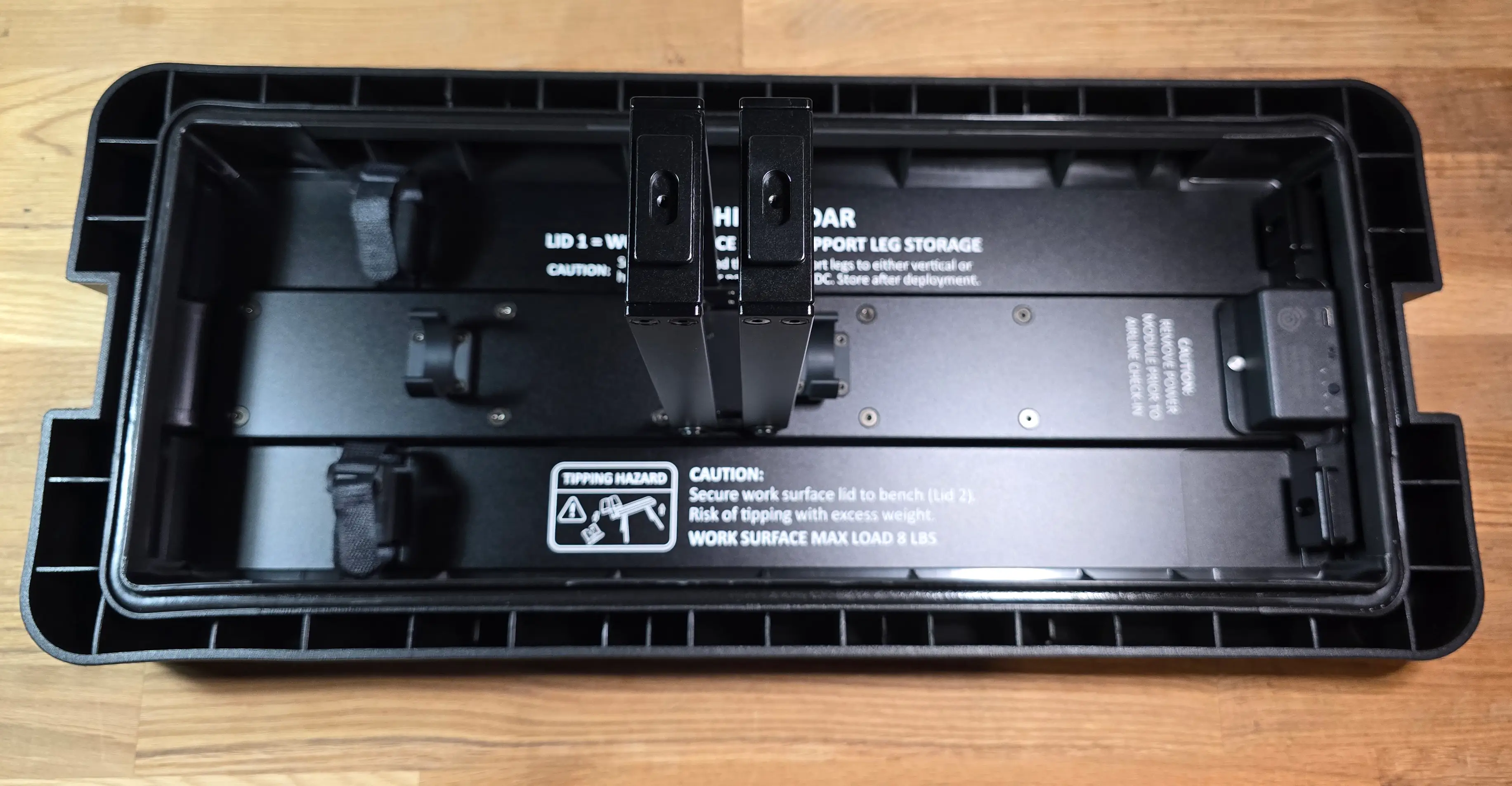 Articulating arms rotated outward on work surface lid